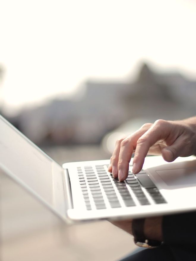 Hands typing on a laptop